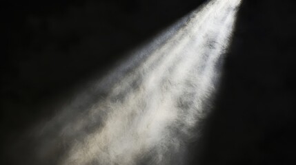 A single focused beam of bright light illuminates swirling particles in a dark atmosphere