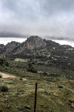 View of rugged mountains under a moody sky, with sparse vegetation clinging to the slopes, showcasing the raw beauty of the landscape, Parco dei Sette Fratelli, Sardinia, Italy.