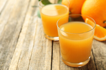 Fresh orange juice and fruits on wooden table, closeup. Space for text