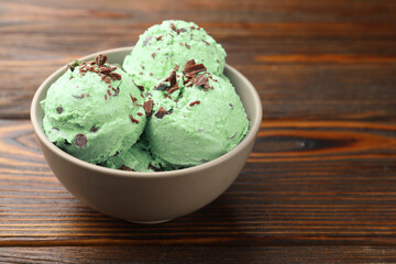 Tasty mint chocolate chip ice cream on wooden table, closeup