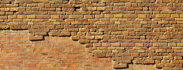 Old weathered brick wall showing crumbling texture background