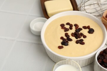 Ingredients for making muffins and whisk on white tiled table, closeup. Space for text