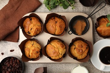 Naklejka premium Tasty muffins with raisins, mint and coffee on grey table, flay lay