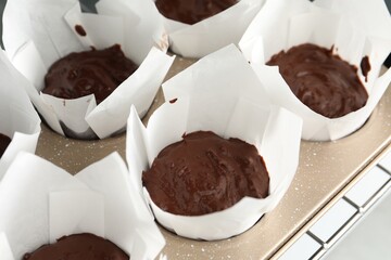 Tasty chocolate muffins baking in oven, closeup