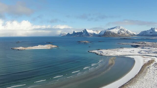 A panoramic drone view of Fredvang Beach in winter shows a dreamlike Lofoten landscape, snowy shores, deep blue sky, and a calm, meditative Arctic atmosphere.