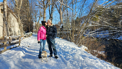Liebespaar mit Hund im Winterurlaub 