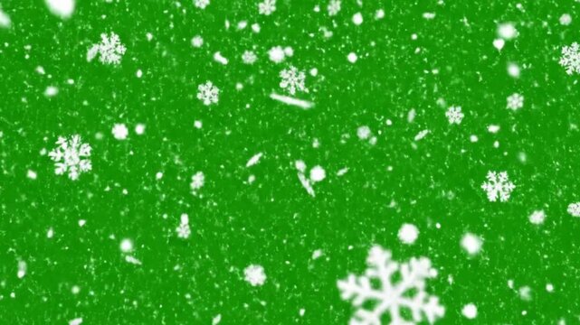 Snowflakes falling on green background in winter wonderland scene