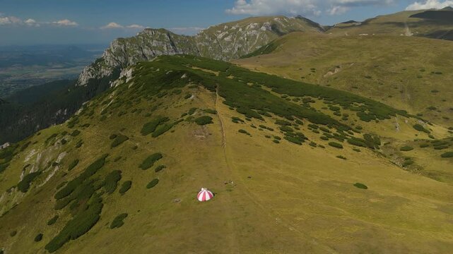 Bucegi Mountains aerial footage departing from Batrana Refuge towards Gutanu and Lancia peaks, revealing the northern Bucegi Plateau with Omu and Costila peaks and vast Pinus mugo slopes in summer