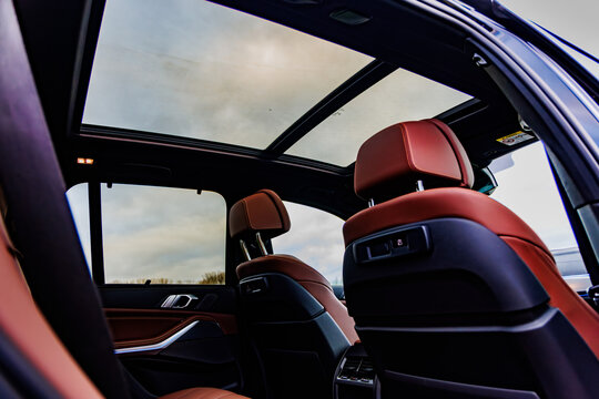 Luxury car interior with red leather seats and sunroof