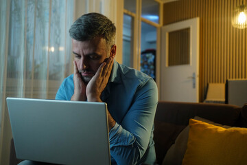 Man stressed while working on laptop