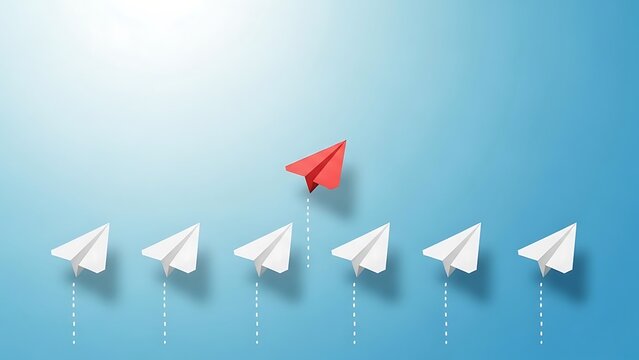 A lone red paper airplane soaring ahead of a group of white paper airplanes in a blue background with sunlight