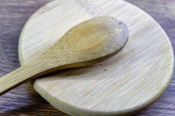 A wooden spoon rests on a wooden cutting board
