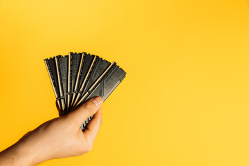 Hand holding fan of black DDR RAM sticks on yellow background, upgrade concept. High quality photo