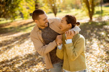 Couple enjoys a sunny autumn day in the park with laughter and joy