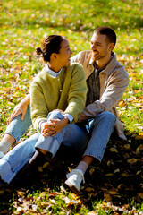 Couple enjoys a sunny autumn day in the park surrounded by colorful leaves