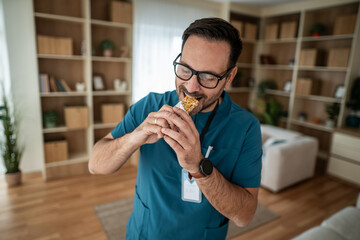 Healthcare worker enjoying quick granola bar snack at home