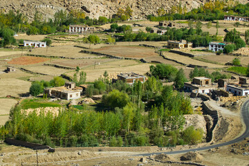 Fototapeta premium Chang La is a high mountain pass in Ladakh in Greater Himalaya between Leh and Shyok River valley. View of Himalayan agriculture and village below as seen from Chang La, on Leh to Pangong Lake road.