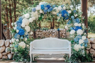 A beautiful decorated place for the wedding ceremony of the bride and groom in oriental style. Wedding arch made of white and blue fresh flowers. Beautiful decorative chandeliers and a white bench