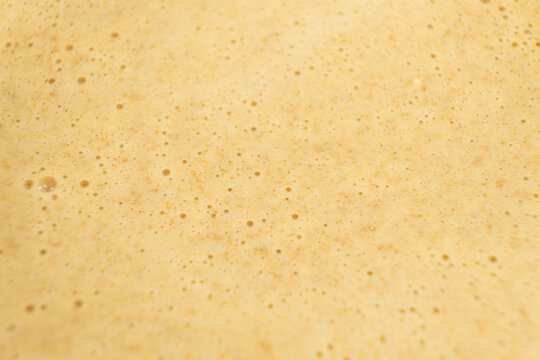 Abstract macro texture of bubbly waffle batter.