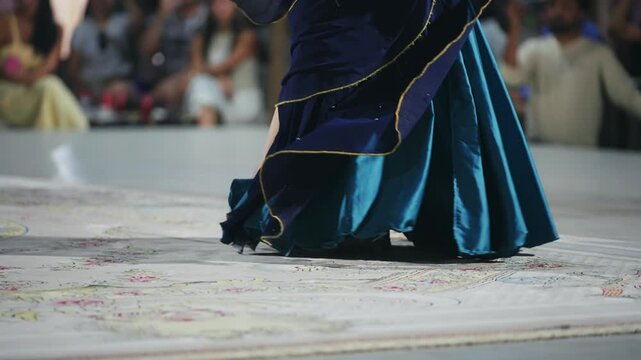 Belly oriental dancing woman with abstract movement of flowing fabric under night lights in the middle east, slow motion