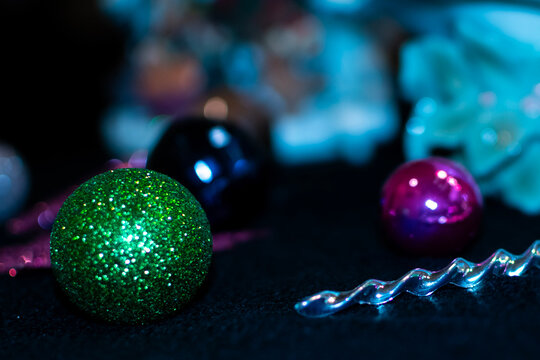 Green sparkling Christmas ornaments on a black background. 