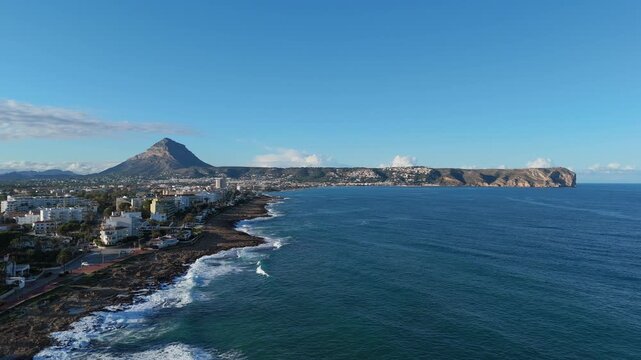 Javea Spain. Panoramic sunset video from Cala Blanca with waves breaking along the coast, Montgo mountain and Cabo SanAntonio in view.