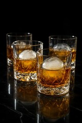 Heavy-bottomed, cut-crystal tumblers, filled with golden Scotch and placed on a reflective black marble surface. The glasses are partially obscured by the condensation from large ice spheres.