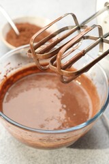 Chocolate dough and mixer on grey textured table, closeup