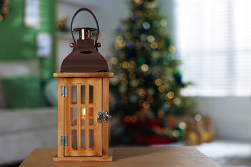 Christmas lantern on wooden table against blurred lights, space for text. Bokeh effect