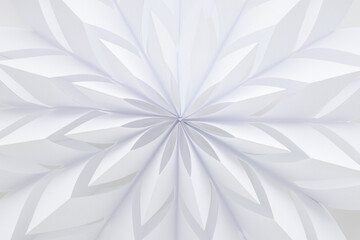 White snowflake shape created from paper on light gray background. Closeup. Handmade decoration element for winter festive. Top down view.