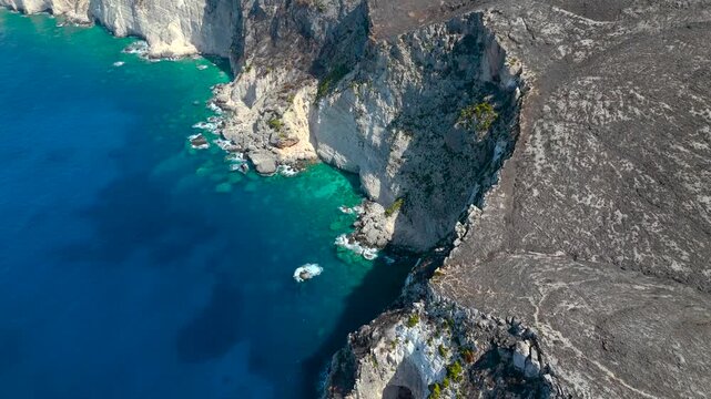 4K Cinematic Aerial Drone View of Plakaki beach in Zakynthos Greece featuring a rocky peninsula turquoise coves and rugged dry hills above the deep blue Ionian Sea