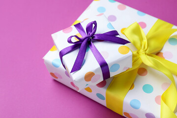 Beautiful gifts on violet background, closeup. Space for text