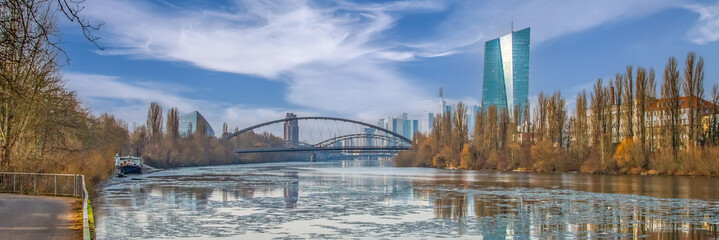 Modern Frankfurt am Main urban skyline with a bridge and river during winter