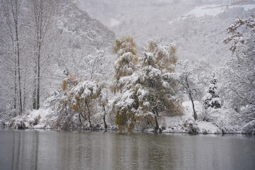 Heavy snowfall over the lake. Soldier Lake in a mountainous area with different vegetation.