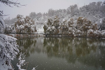 Heavy snowfall over the lake. Soldier Lake in a mountainous area with different vegetation.