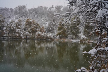 Heavy snowfall over the lake. Soldier Lake in a mountainous area with different vegetation.