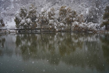 Heavy snowfall over the lake. Soldier Lake in a mountainous area with different vegetation.