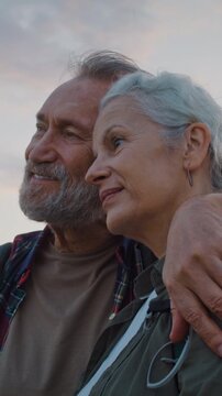 Senior family couple faces rest together and smile at soft sunset