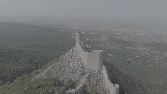 Cinematic aerial view of the historic Chirag Gala fortress on top of a rocky mountain with flat log profile, Azerbaijan
