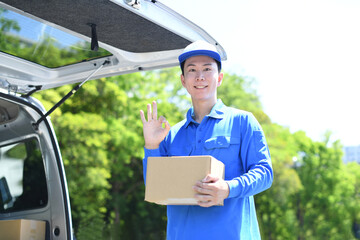 屋外で配送スタッフが荷物を持ちOKをする