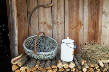 Objects of ancient village life near a wooden wall.