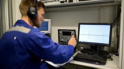 Specialist operates diagnostic equipment to detect and troubleshoot audio signal variations ensuring precise sensordriven sound quality monitoring.