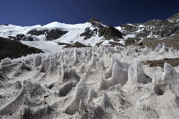 The enchanting beauty of the snowy mountains. The view of snow and rocks on the mountain tops.