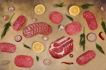 Delicious, aromatic appetizers of various salami cuts for the holidays. A selection of various smoked and dry-cured sausages and spices on a kitchen background. Advertising and menu for a store