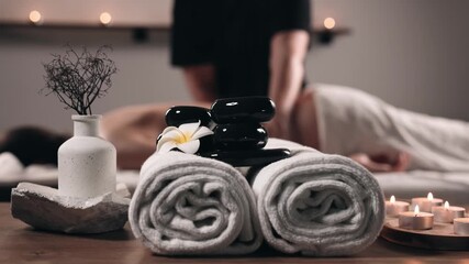 Relaxing massage therapy session in a calm spa environment with soft towels, smooth stones and candles, expressing deep relaxation and body care. Concept wellness, harmony, stress relief - Powered by Adobe