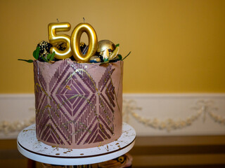 Fifty years birthday cake with gold and silver decoration and number 50