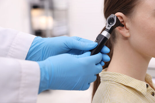 Hearing test. Doctor examining patient&rsquo;s ear with otoscope in clinic, closeup