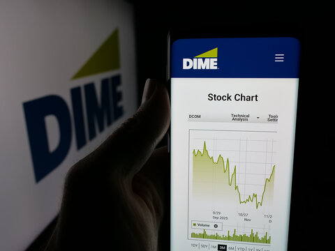 Stuttgart, Germany - 12-05-2025: Person holding smartphone with web page of US financial company Dime Community Bank on screen in front of logo. Focus on center of phone display.
