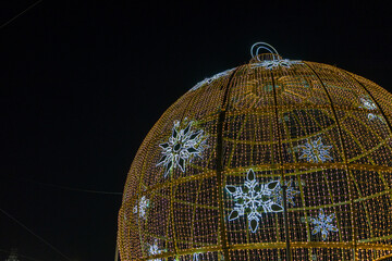 Golden christmas ornament with glowing snowflakes at night