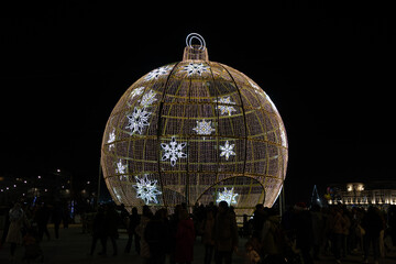 Giant christmas ornament shining with snowflake decorations at night